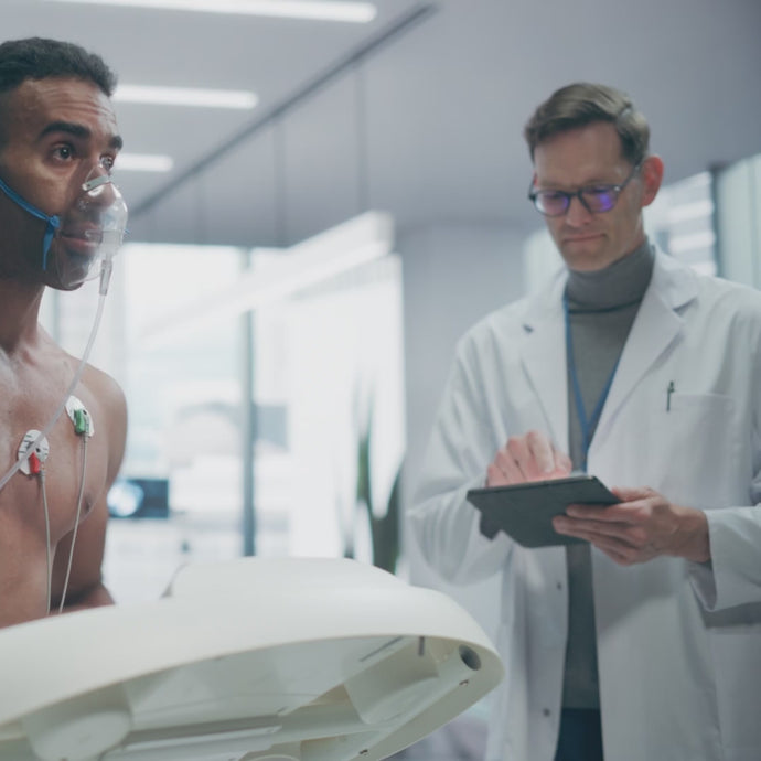 Biohack video showing a fit man with electrodes attached and running on a treadmill and a doctor taking notes.